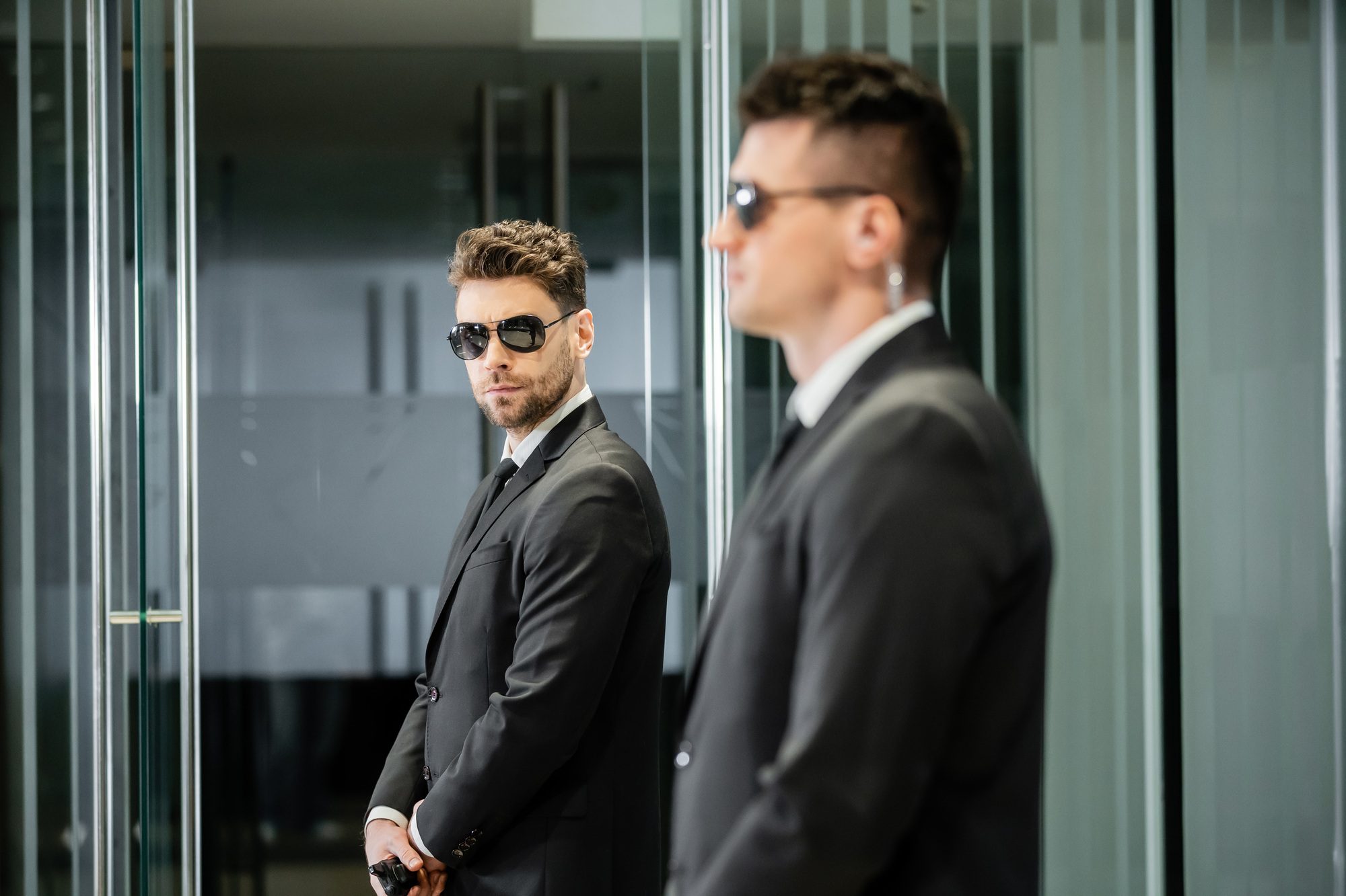 bodyguard service, hotel security, handsome man in suit and sunglasses standing in lobby near work bodyguard service, hotel security, handsome man in suit and sunglasses standing in lobby near work